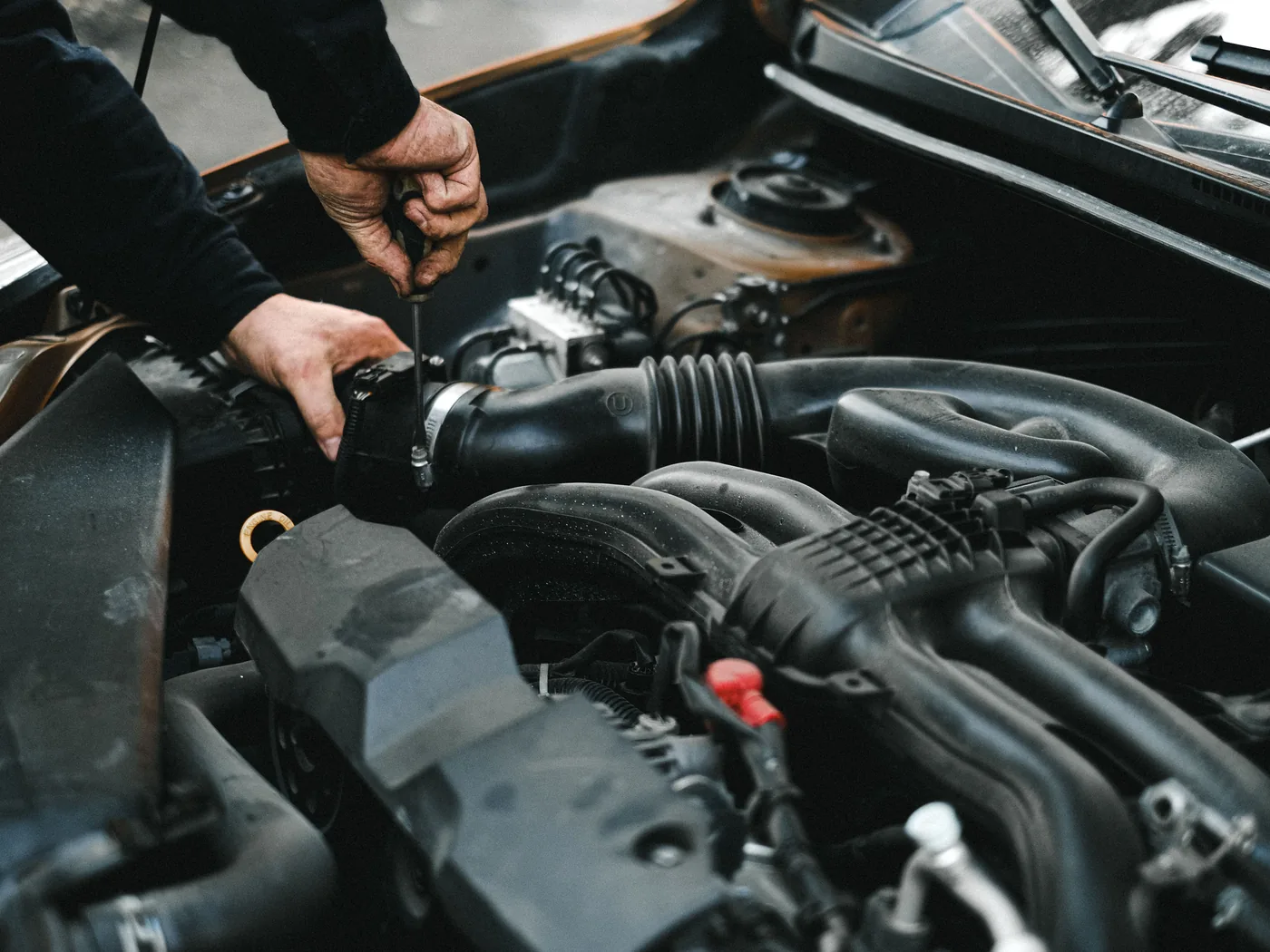 Dłonie mechanika podczas pracy przy silniku samochodu